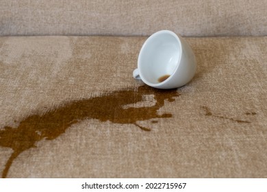 Spilled Cup Of Coffee On The Sofa With Dirty Stain.