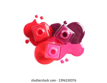 Spilled different nail polishes and bottles white background  top view