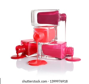 Spilled different nail polishes and bottles white background
