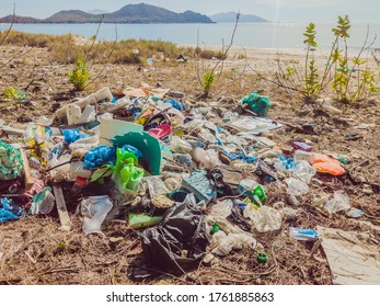 Spilled garbage on the beach. Empty used plastic, boxes and ropes. Dirty sea sandy shore. Environmental pollution. Ecological problem. Ocean Dumping - Total pollution
