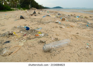 Spilled Garbage On The Beach. Empty Used Dirty Plastic Bottles. Environmental Pollution. 