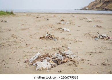 Spilled Garbage On The Beach. Empty Used Dirty Plastic Bottles. Environmental Pollution. Ecological Problem