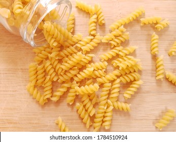 Spilled Pasta On The Wood Plate With Jar