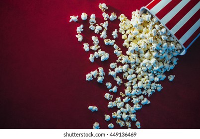 Spilled Popcorn On A Red Background, Cinema, Movies And Entertainment Concept