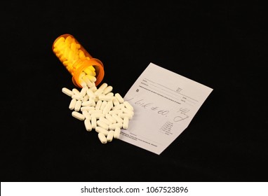 Spilled Prescription Pills Over A Prescription Pad On A Black Background