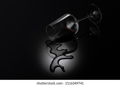 Spilled Wine Glass On A Black Background With Reflection