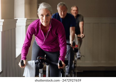 Spin class, fitness or senior woman on bike in workout or training for cycling progress, health or wellness. Group, challenge or confident elderly person on bicycle machine for gym or cardio exercise - Powered by Shutterstock