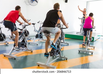 Spin Class Working Out With Motivational Instructor At The Gym