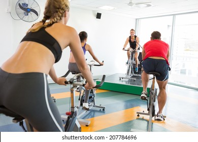 Spin Class Working Out With Motivational Instructor At The Gym