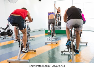 Spin Class Working Out With Motivational Instructor At The Gym