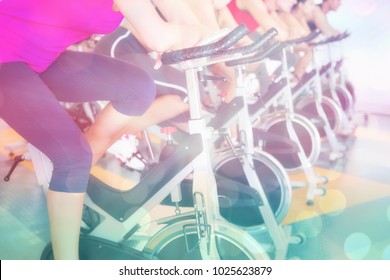 Spin Class Working Out In A Row Against Abstract Background