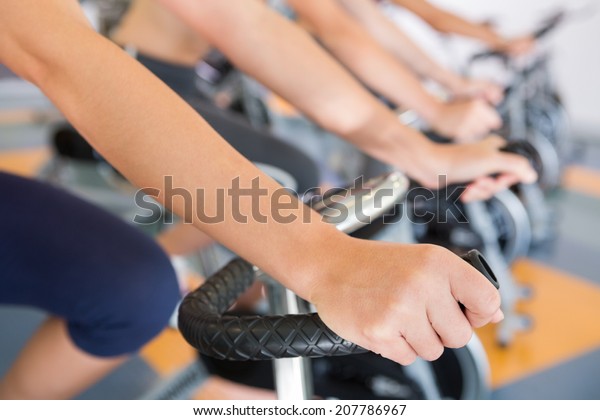 Spin class working\
out in a row at the gym