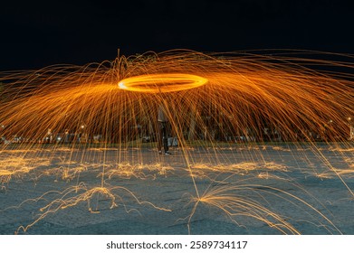 Spin fire dancing show, long exposure at the night time.Line of light in circle from fire swing dancing.Spinning and burning Steel wool sparkle fire in the circle shape.