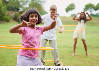 Spin like yourve never spun before. Three children playing with hula hoops outside. - Powered by Shutterstock