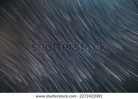 Spin Of Unusual Amazing Stars Effect In Sky. Abstract Bewitching Illusion Of Star Trails. Meteors Trace On Night Dark Blue Sky Background. Soft Colors.