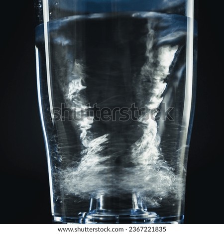Spin water in glass, Abstract black background, water splash with bubbles.