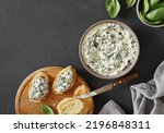 Spinach appetizer or dip with bread, top view, dark background, copy space