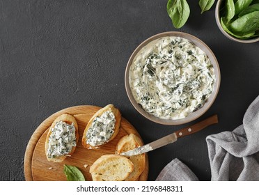 Spinach appetizer or dip with bread, top view, dark background, copy space