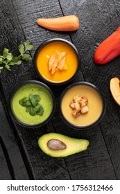 Spinach Cream Soup, Pumpkin And Avacado Soups In Food Containers, Flat Lay. Wooden Background, Vertical