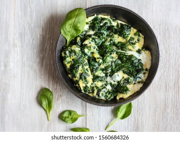 Spinach With Eggs (omelette) On Wooden Table.