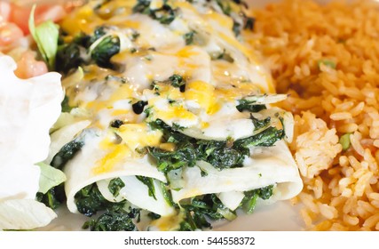 Spinach Enchiladas, Rice And Lettuce And Tomato On A Plate