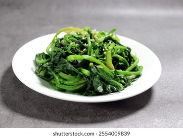 Spinach greens blanched in boiling water. Spinach vegetables seasoned with salt and sesame oil.
