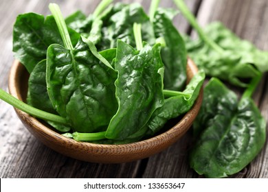 Spinach leaves in a wooden plate - Shutterstock ID 133653647