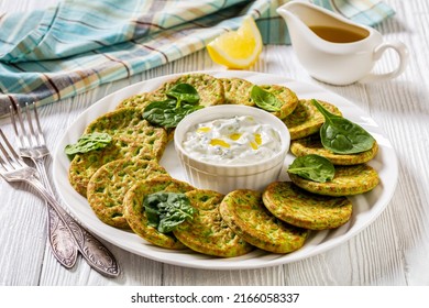 Spinach Pancakes On White Plate With Tzatziki Sauce On White Wooden Table With Forks, Horizontal View From Above