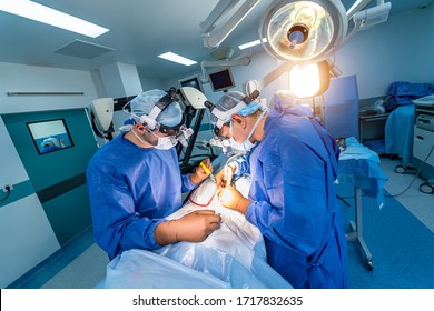 Spinal Surgery. Group Of Surgeons In Operating Room With Surgery Equipment. Doctor Looking At Screen. Modern Medical Background