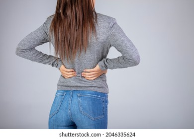 Spine osteoporosis. Scoliosis. Spinal cord problems on woman's back. Attractive female person suffers from backache. All on gray background. Painful back on female body 