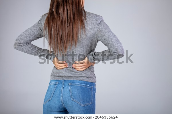 Spine\
osteoporosis. Scoliosis. Spinal cord problems on woman\'s back.\
Attractive female person suffers from backache. All on gray\
background. Painful back on female body\
