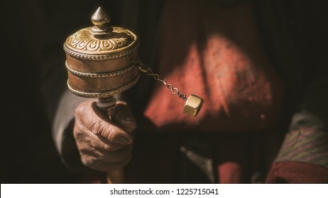 Spinning Brass prayer wheel in an old lady tibatan hand.