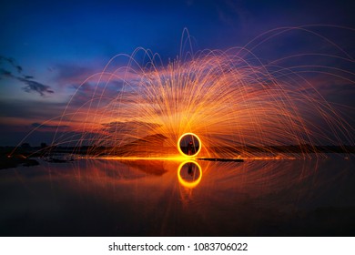 spinning burning steel wool in the River sunset, - Powered by Shutterstock