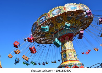 Spinning carousel ride with swings at amusement park.