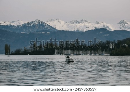Spinning duck boat in lake lucerne, Switzerland with snow mountains peak view.