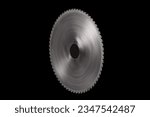 Spinning giant circular saw blade with big cutting teeth isolated on a black background
