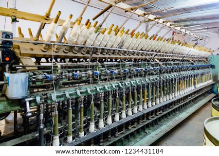 Spinning production line. Spinning machinery with spindles and wool yarns.