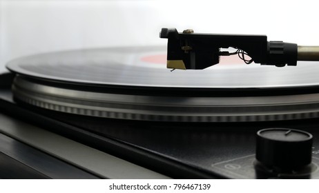 Spinning Record Player With Vintage Vinyl. Turntable Player And Vinyl Record With Dropping Stylus Needle Running Old CD And Playing Music on White Background