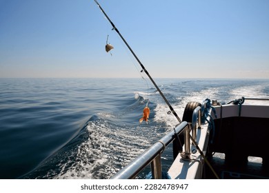 A spinning rod for catching fish with shrimp bait is rigged on board the fishing boat. - Shutterstock ID 2282478947