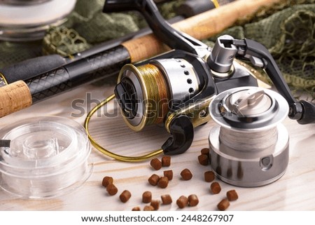 Spinning rods, reels, items for sport fishing, on an old background.