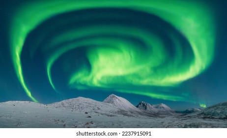 A spiral Aurora Borealis over the Northern Norway near Tromso. High quality panorama northern lights