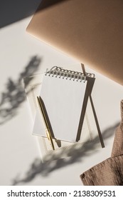 Spiral Flip Notebook With Blank Copy Space, Pen, Laptop Computer In Flowers Sunlight Shadow On White Table. Aesthetic Bohemian Minimalist Workspace. Artist, Writer Template