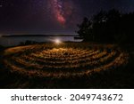 Spiral labyrinth made of stones on the coast at starry night.