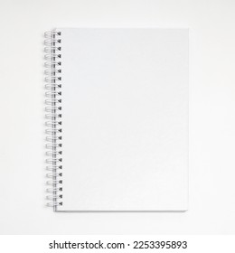 A spiral notebook from top view with empty white cover - Shutterstock ID 2253395893