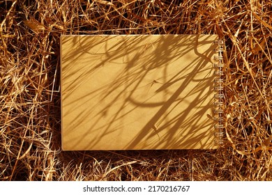 Spiral Scrapbook With Brown Pages On Dry Grass In The Sunny Garden.