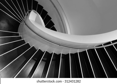 Spiral Staircase In A Contemporary Building With Interiors Designed In Style Of Minimalism. Sample Image Of Modern Architecture With Distinguishing Shades Of Black And White.