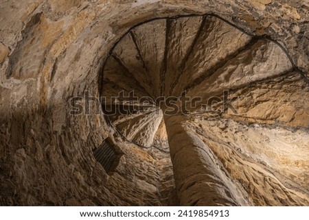 Spiral staircase in a historic castle ruin.