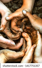 A spiral of white hands full of brown dirt and soil inspiring cooperation, working together as a group, in a permaculture workshop, in Quebec, Canada