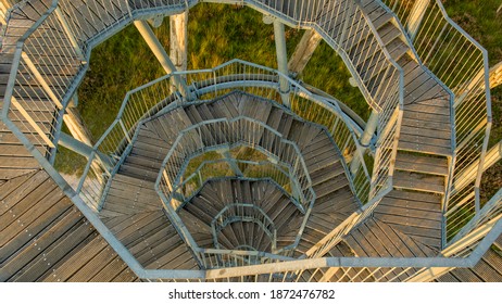 a spiral wooden staircase with view downwards