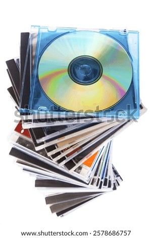 Spiraling stack of music CDs. Blank CD on top with a rainbow reflection.